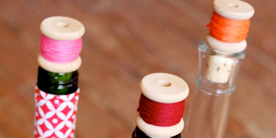 Con una bobina de hilo de algún color que nos guste, pegamento y un simple corche de una botella de vino conseguiremos un tapón de lo más original. Basta con poner algo de pegamento sobre el hilo para que se mantenga con su forma original y no se deshaga. Después, pondremos también pegamento en la base de la bobina y la pegaremos al corcho. Una vez que se haya secado bien, nuestras botellas tendrán un aspecto de lo más divertido.